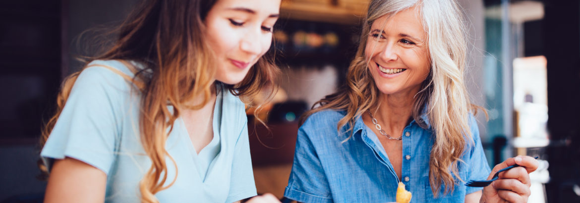 Beautiful senior mother and daughter eating lunch together at restaurant