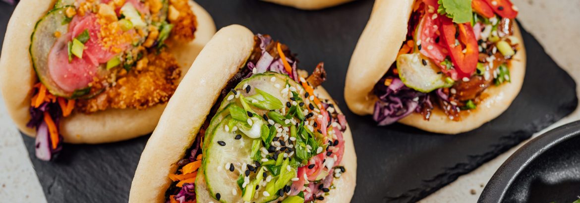 A closeup shot of steamed bao buns on a black surface
