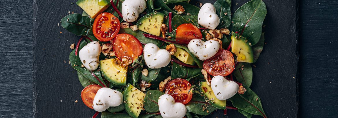 heart-shaped mozzarella vegetarian salad with avocado, tomato and nut sauce