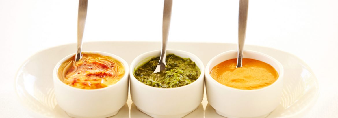 Three bowls of different dips in a row, hummus, guacamole and Cheese. Horizontal composition.