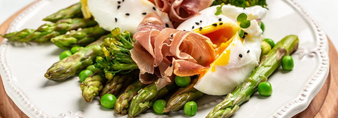Tasty asparagus, poached egg and jamon, ham, prosciutto. Healthy food. diet lunch concept. Keto Paleo diet menu.
