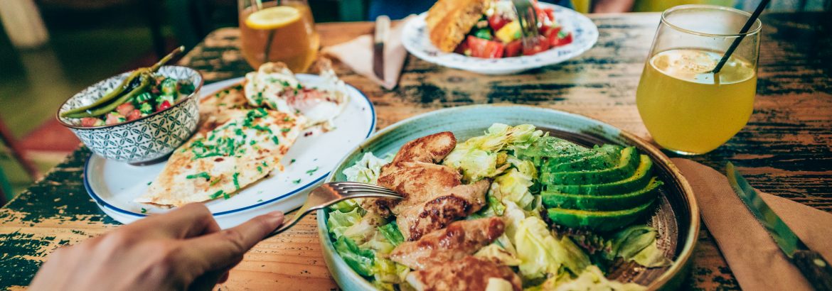 Woman and man sharing their healthy lunch or dinner at restaurant.