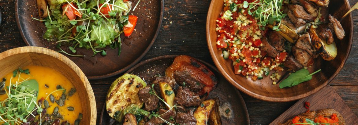 Roasted pumpkin soup with beans. Skirt steak with grilled vegetables. Turkey skewers and bulgur salad. Red pepper bruschetta. Salad with vegetables. Flat lay top-down composition on wooden background.