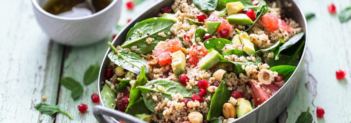 Winter Salad with Quinoa, Avocado, Blood Orange, Pomegranate, Bulgur, Hazelnuts on blue Background