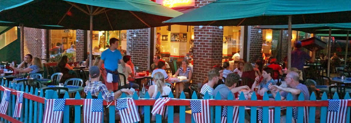 Washington DC, USA-July 7, 2014:  These diners are dining at a neighborhood Mexican restaurant in Cleveland Park in Northwest Washington DC after the fourth of July on a Monday night.  American flags adorn the fence and these people are extending their fourth of July weekend by dining out.