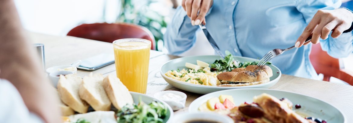 Couple having healthy breakfast in modern restaurant. People eating out together