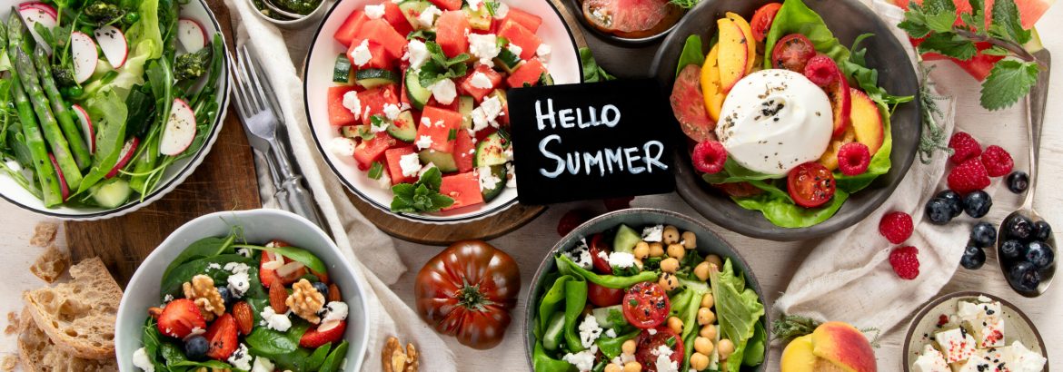 Various summer salads with strawberry, herbs. Healthy salad with arugula,  peaches, burrata, blueberries and walnuts on a light background.  Fresh useful dish for healthy eating. Top view.