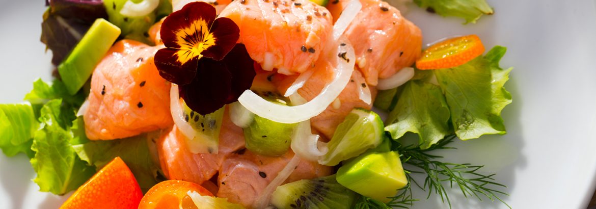 Salmon ceviche with avocado, kumquat and dill served on plate