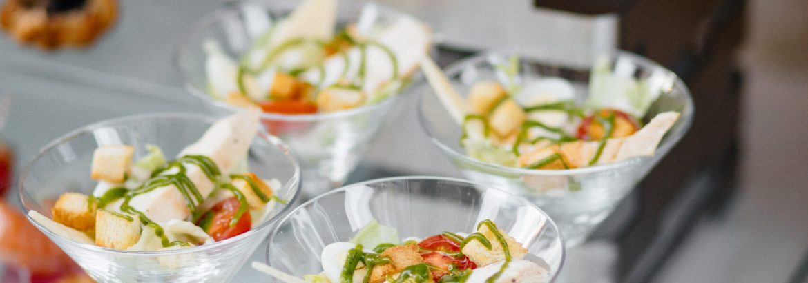 Served dishes to the table for holiday. Cutlery and food on white tablecloths in the restaurant. Design a festive Banquet. Luxurious food for guests and visitors.