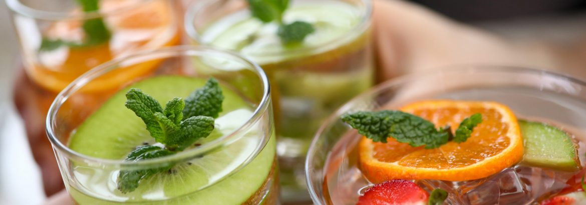 Group friends hold fruit cocktails in hand closeup christmas party. Xmas celebration concept