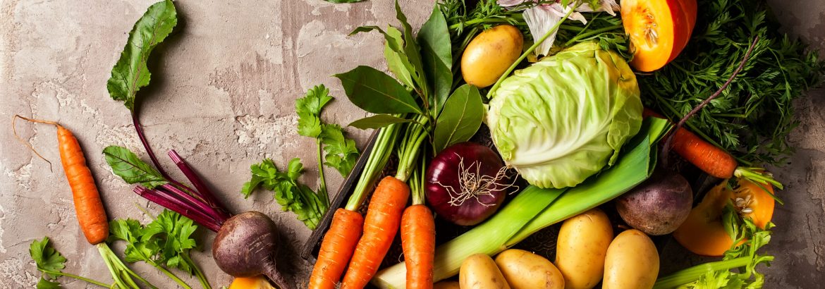 Variety of fresh raw vegetable ingredients for cooking of vegetable soup or stew. Autumn vegetable still life on rustic vintage background. Top view