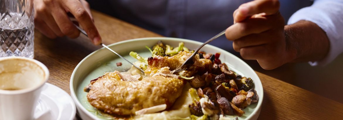 Close up of unrecognizable man eating lunch in a restaurant.