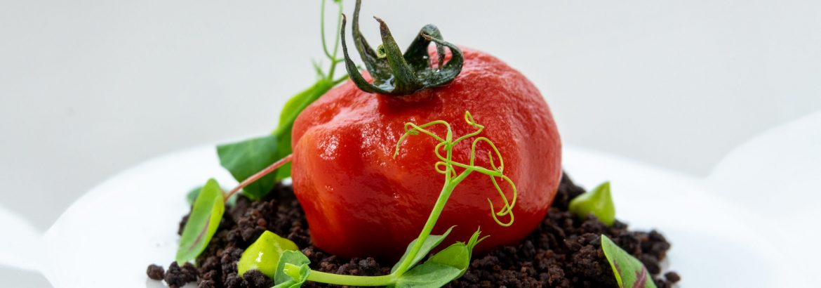 Dish with whole tomato and squid ink rice